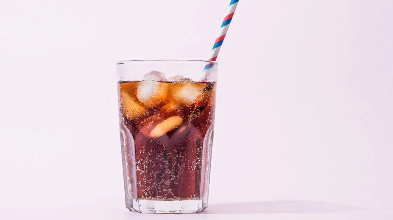 glass of soda with straw in it
