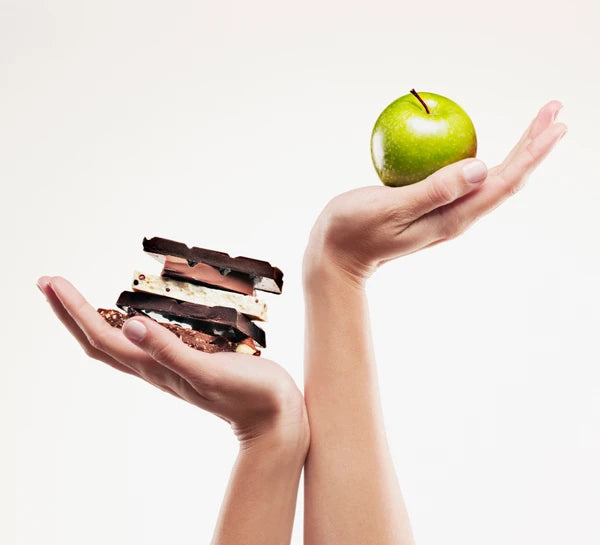 apple and chocolate being held up in hand