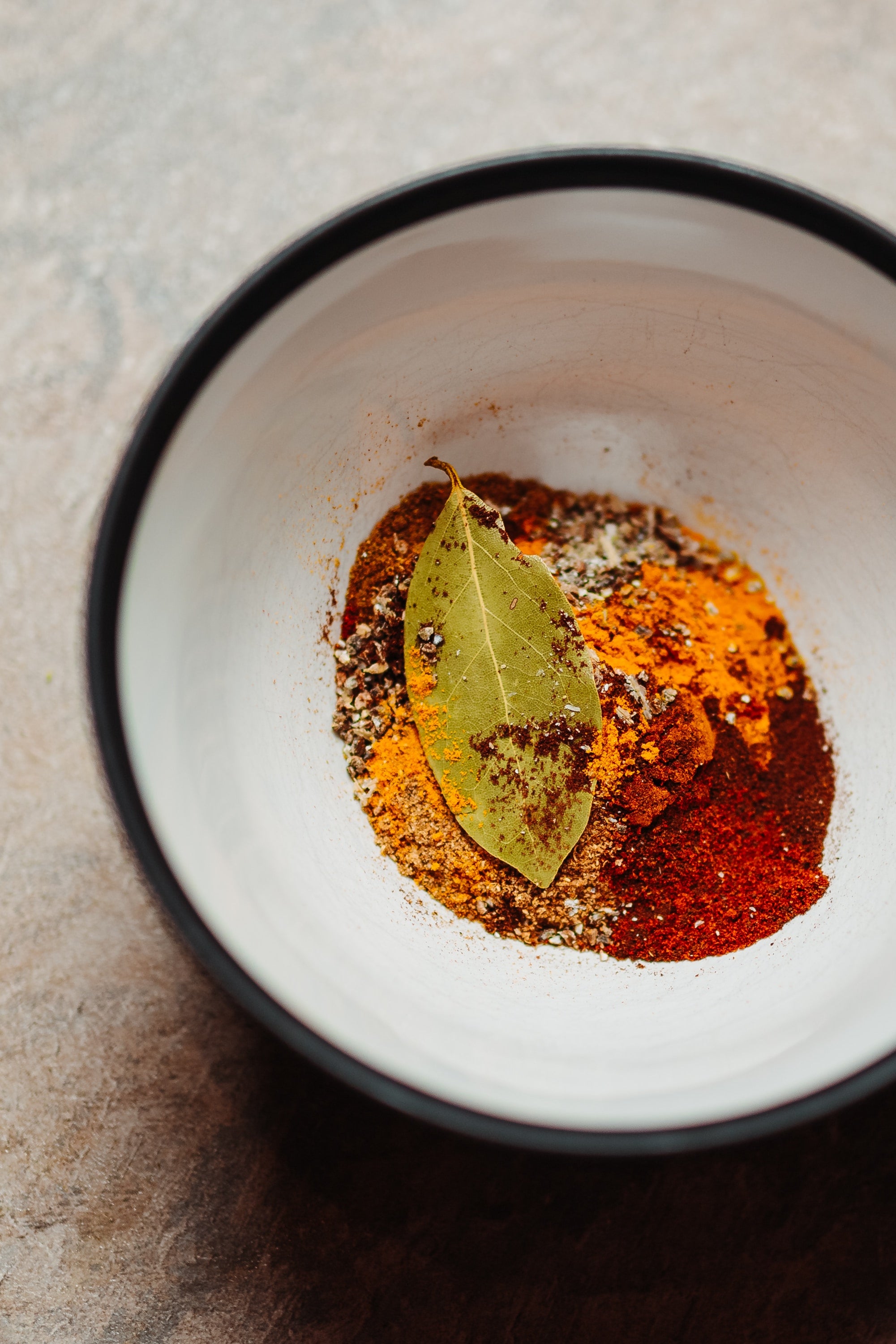 turmeric and other spices in a white bowl