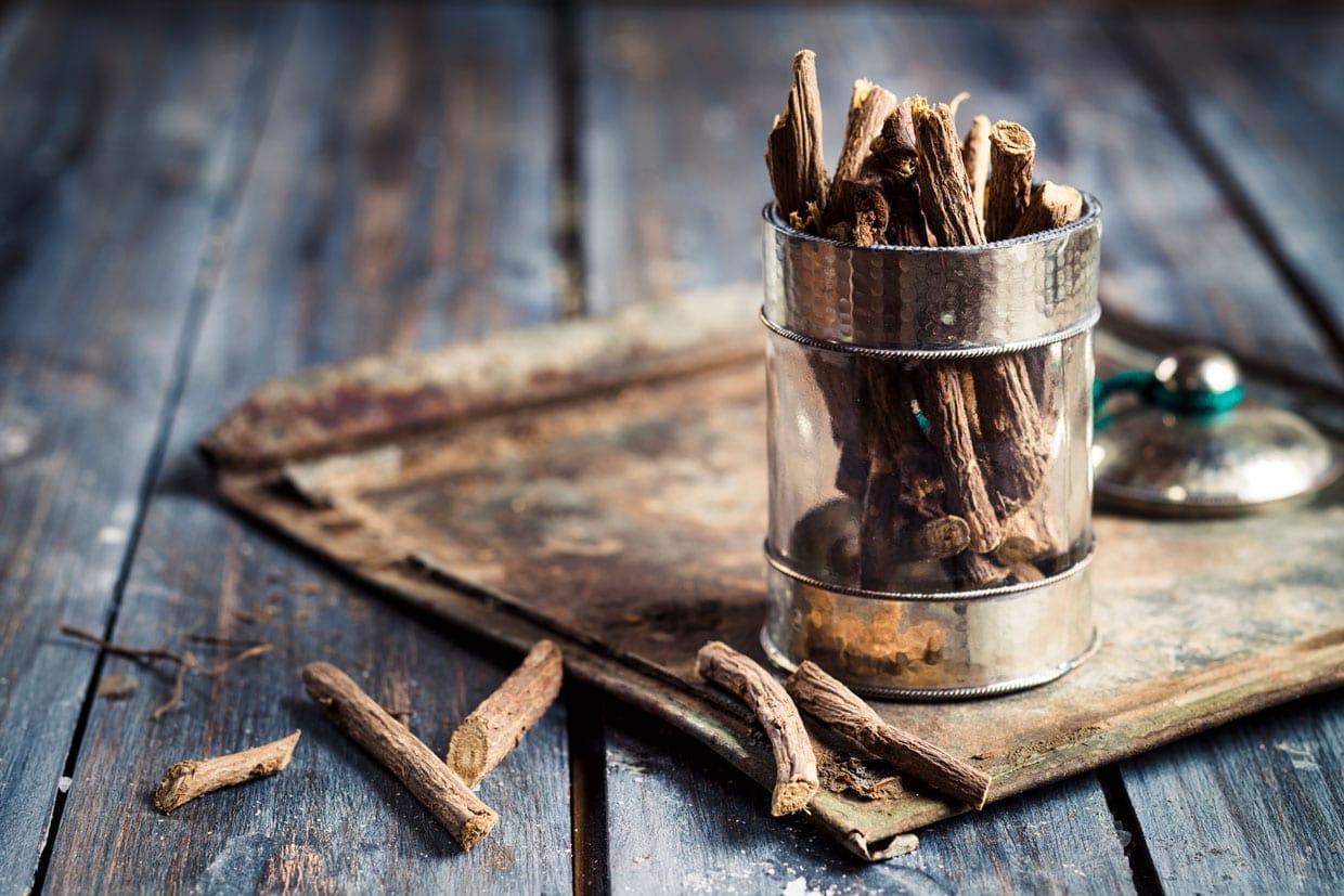 licorice root sitting in a jar on a wooden table